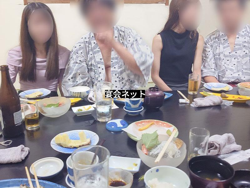 男女で密着して宴会料理を楽しむ