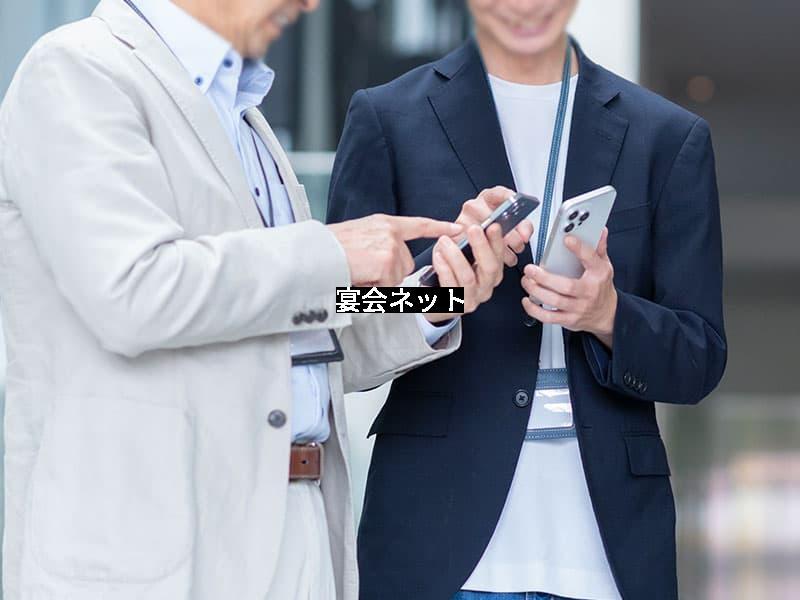 男性2人がスマホから予約する