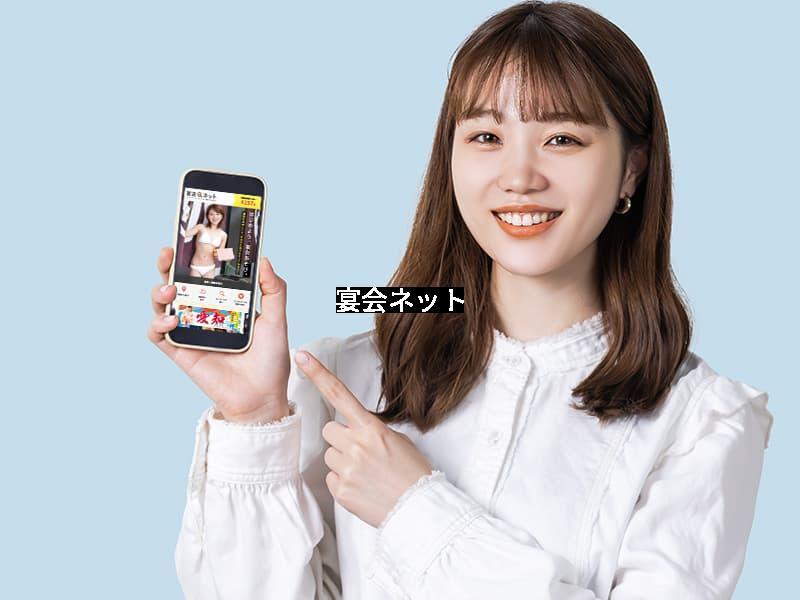 スマホから予約するセミロングの白い服を着た女性
