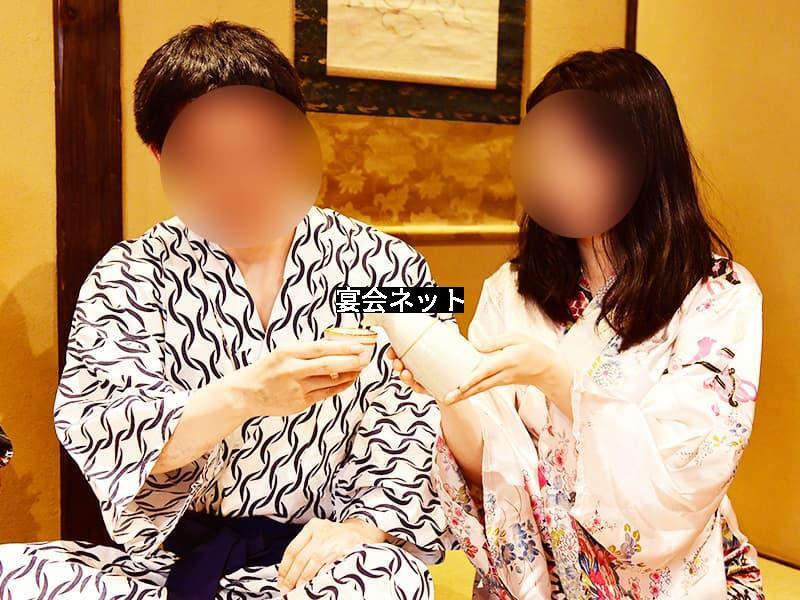 浴衣姿の美人ノーマルコンパニオンにお酌してもらう男性