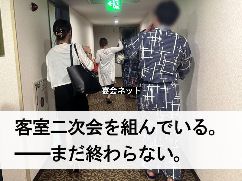 旅館の廊下を移動する男女