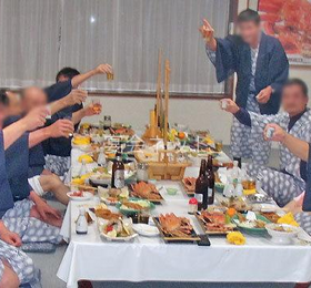 旅館で乾杯する男性7名と接待コンパニオン1名